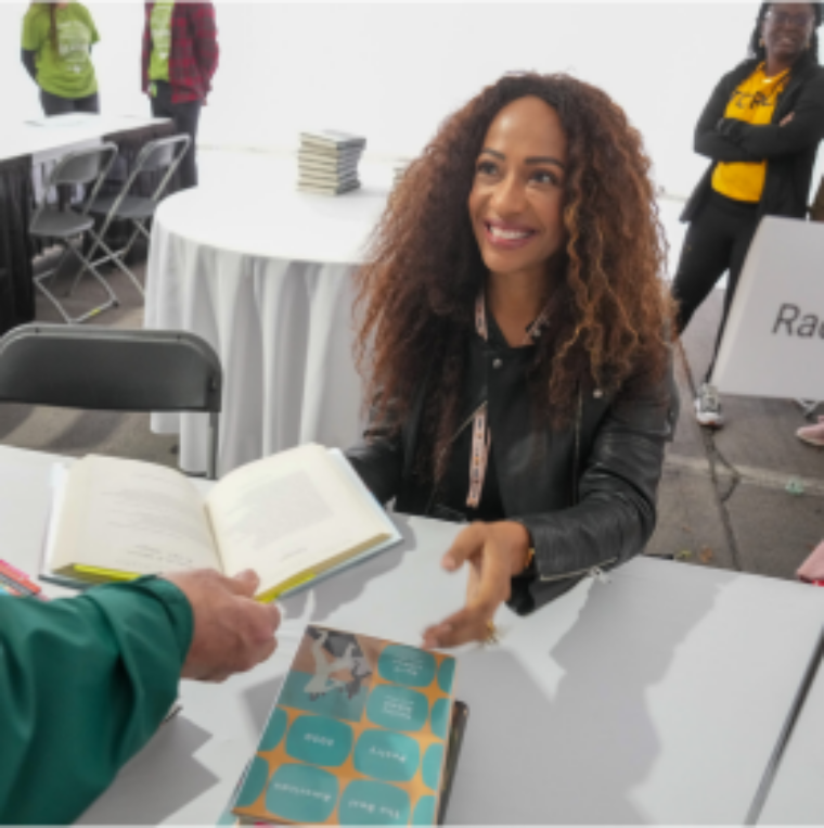 Image of author at Texas Book Festival signing an attendees book